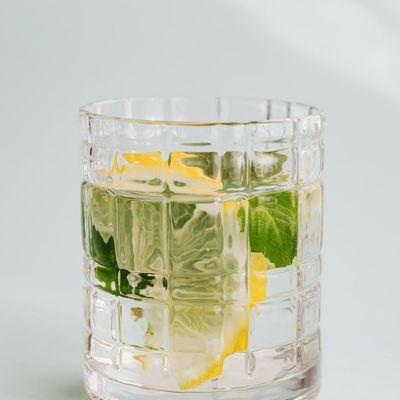 A glass of water with lemon next to a workout space.