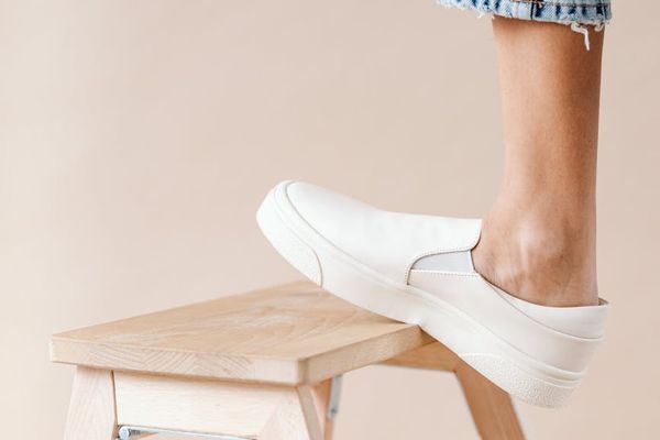 A pair of comfortable sneakers on a wooden floor.