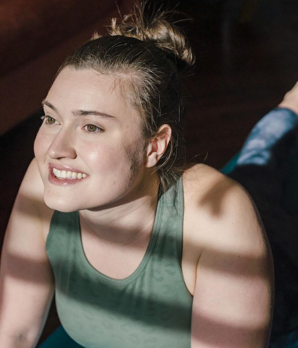 Person in comfortable clothes stretching gently in a sunlit room.